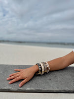 Elise cloisonné bracelet worn at the beach – midnight black enamel with gold flowers"