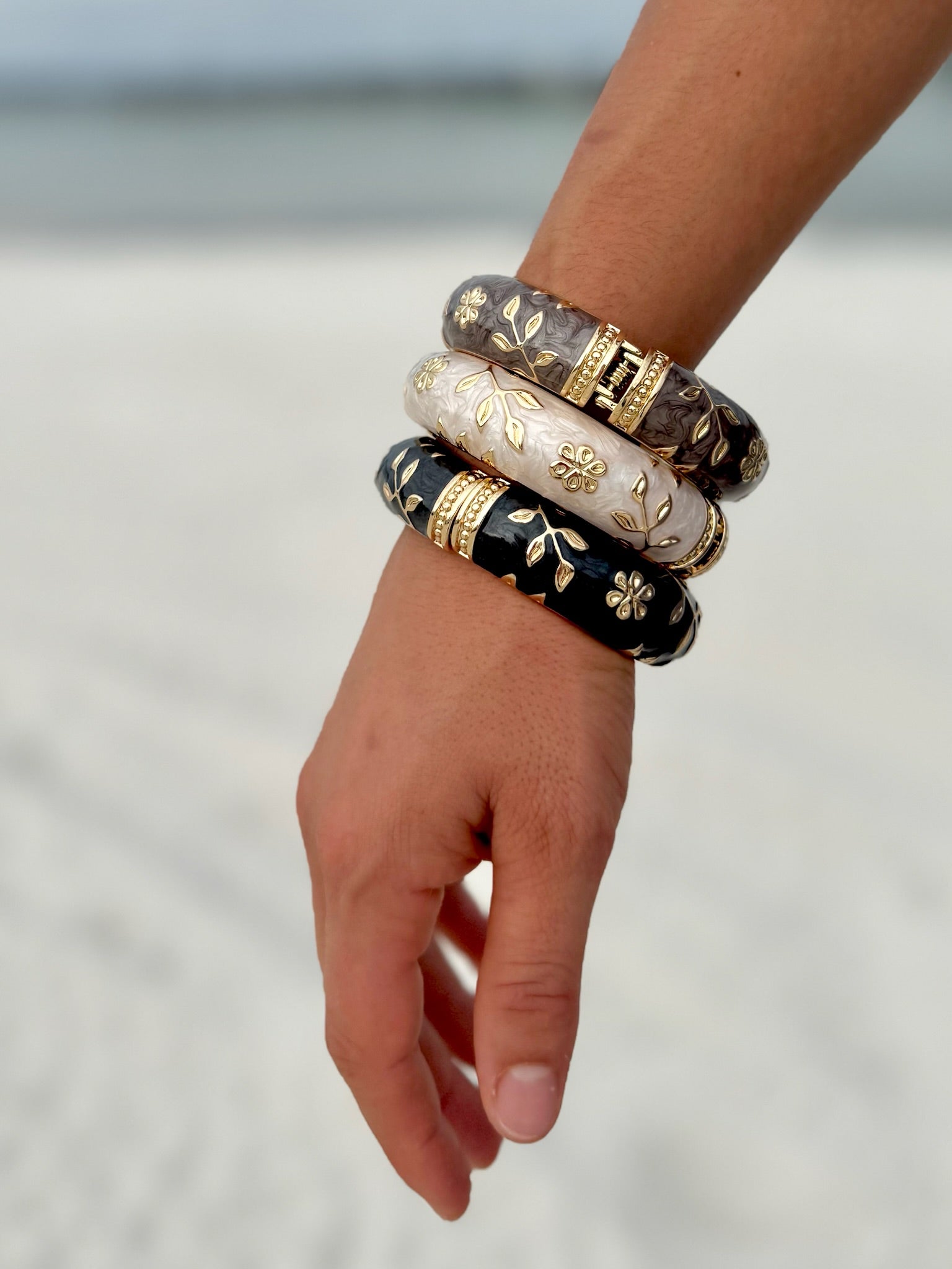 Elise cloisonné bracelet worn at the beach – midnight black enamel with gold flowers"