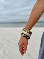"Elise cloisonné bracelet worn at the beach – dove grey enamel with gold flowers"