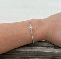 Sparkly Silver Cuff with a pearl in the center on model. 