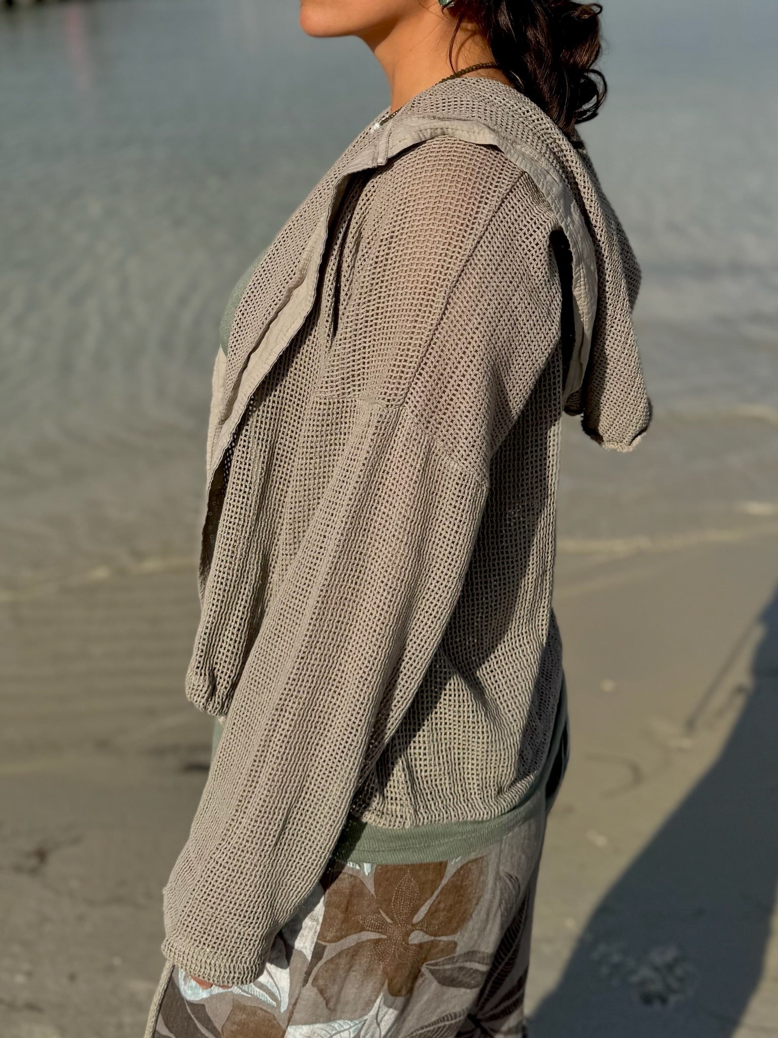 Side profile of the taupe Gia Mesh Hooded Jacket highlighting the open-knit texture, draped hood, and relaxed sleeves.