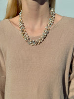 Necklace worn by a person against a neutral background
