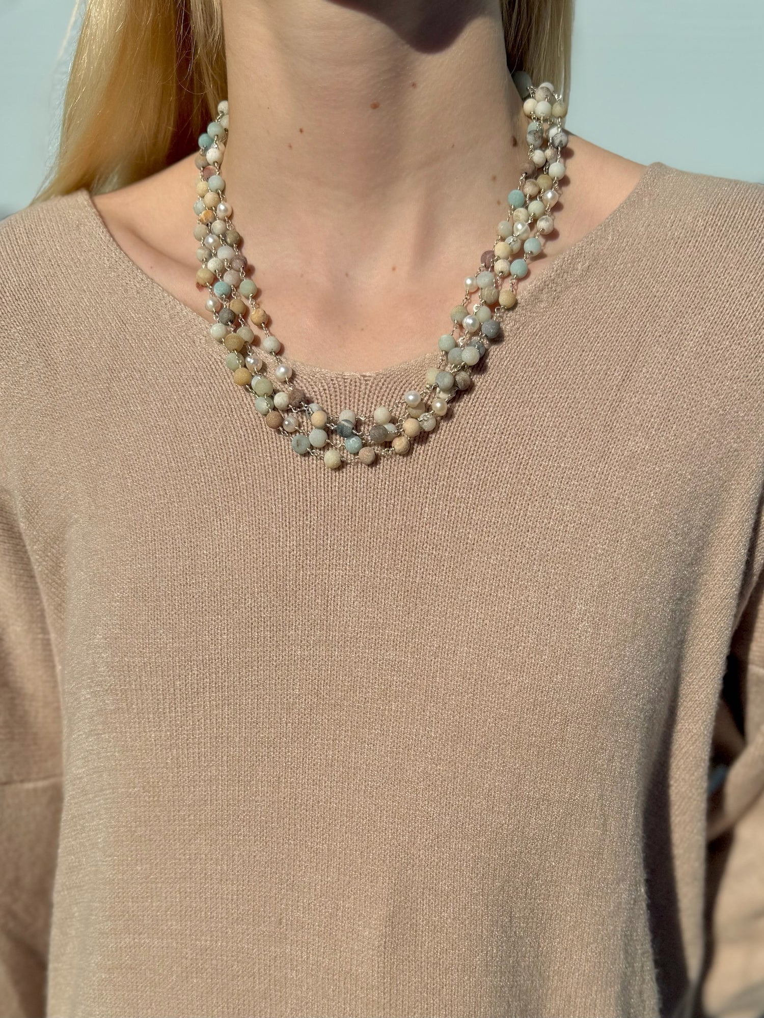 Necklace worn by a person against a neutral background