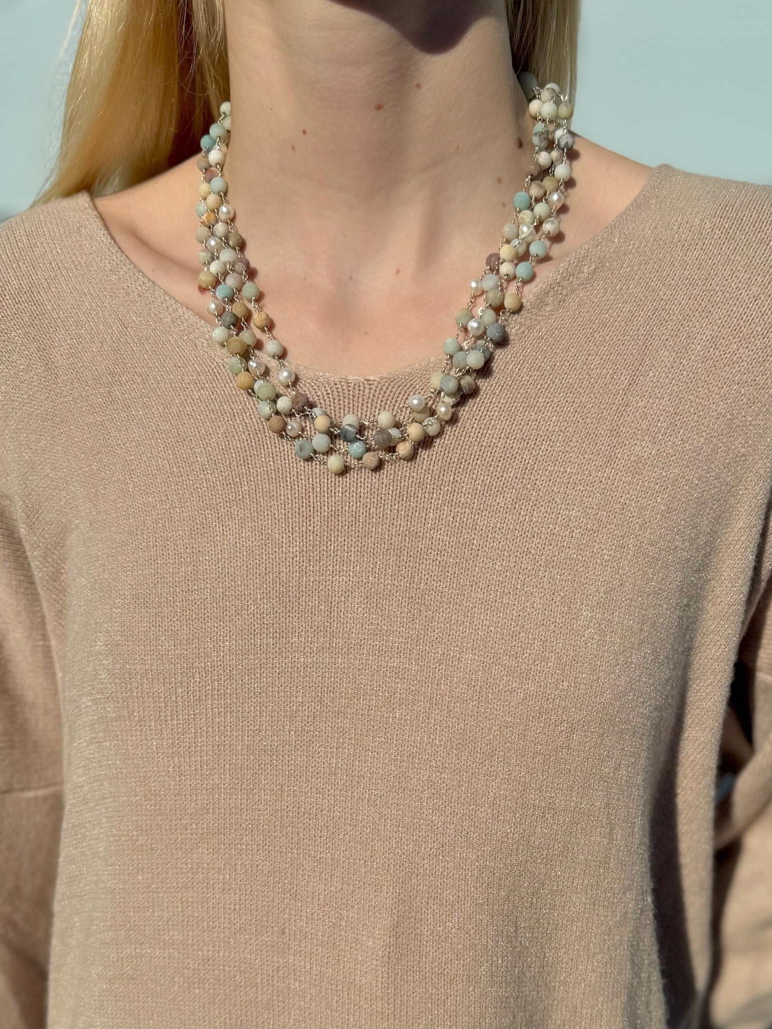 Necklace worn by a person against a neutral background