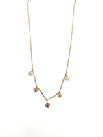 Gold necklace with small round pendants on a white background
