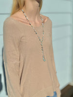 Colette amazonite and freshwater pearl necklace being worn with a beige sweater side view