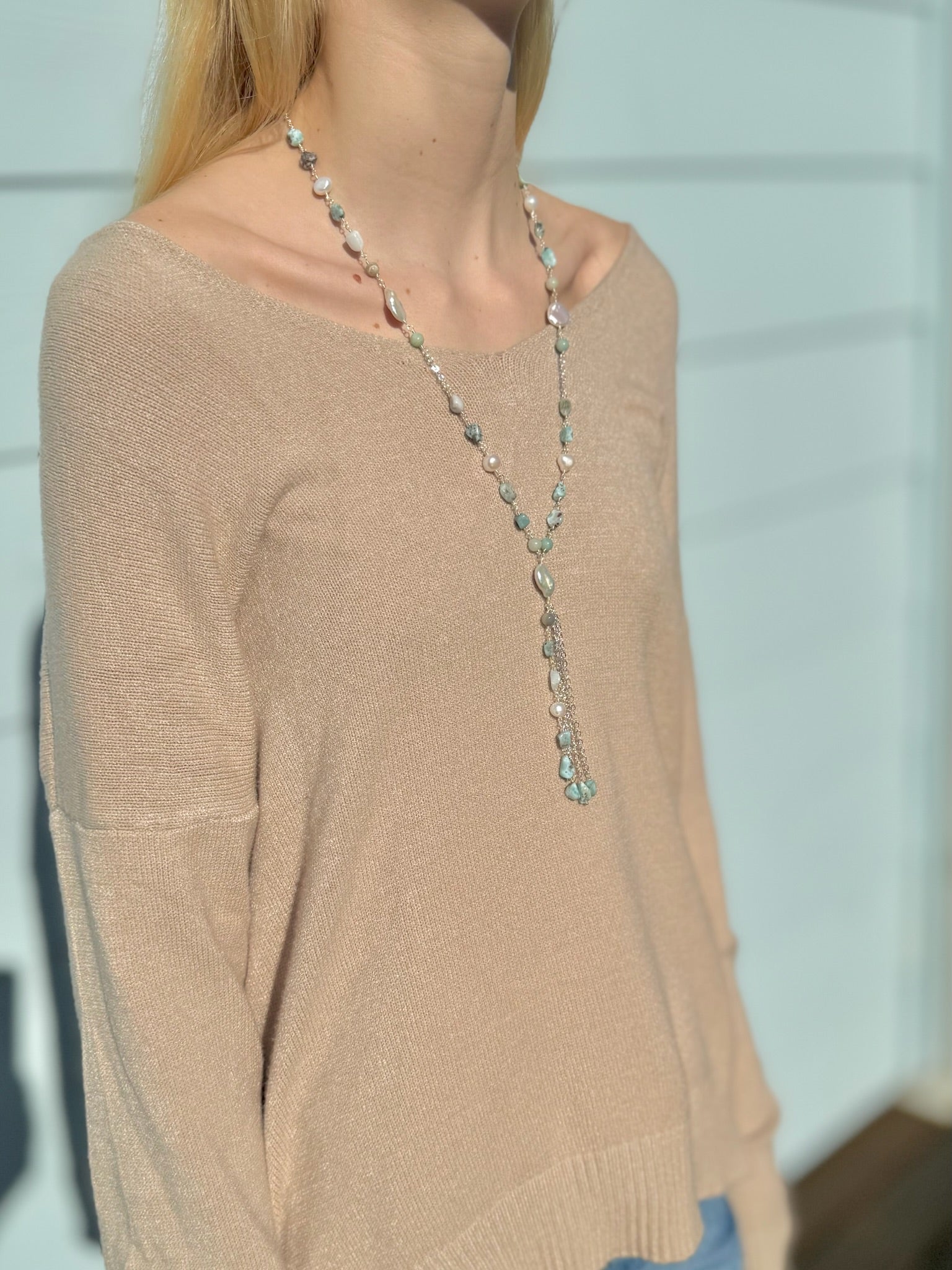 Colette amazonite and freshwater pearl necklace being worn with a beige sweater side view