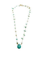 gold-toned necklace with scattered green and turquoise gemstone chips and a large central turquoise teardrop pendant