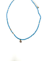 Tessa Necklace with turquoise seed beads, gold accents, and delicate charm at Ardor Boutique.