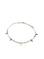 Necklace with small beads and petite gold accents on a white background