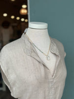 Green gemstone and freshwater pearl pendant necklace styled with the Sharon Linen Dress in Oatmeal Beige, featuring a delicate gold chain and organic pearl accent against a soft Italian linen split neckline.

