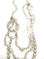 Pearl and gold beaded necklace on a white background