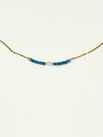 Blue apatite bead and freshwater pearl bar necklace on a gold-tone stainless steel chain, photographed on a white background.