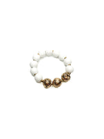 White beaded bracelet with gold accents on a white background