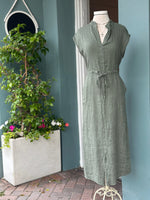 Rich olive green linen midi dress with a split neckline, cap sleeves, adjustable drawstring waist, and side pockets. Made from breathable crinkle-textured linen with an effortless, relaxed silhouette.