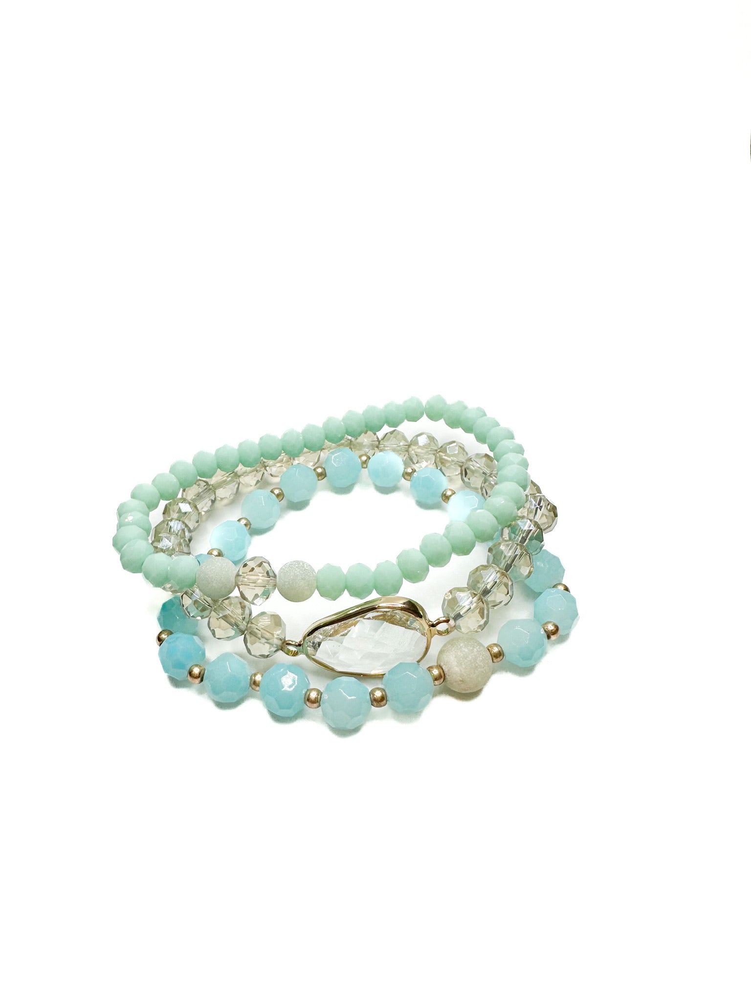 Set of three blue and clear beaded stretch bracelets with faceted stone and gold accents displayed on white background.