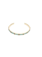 Gold open cuff bracelet with turquoise enamel and clear crystal accents, shown on white background.