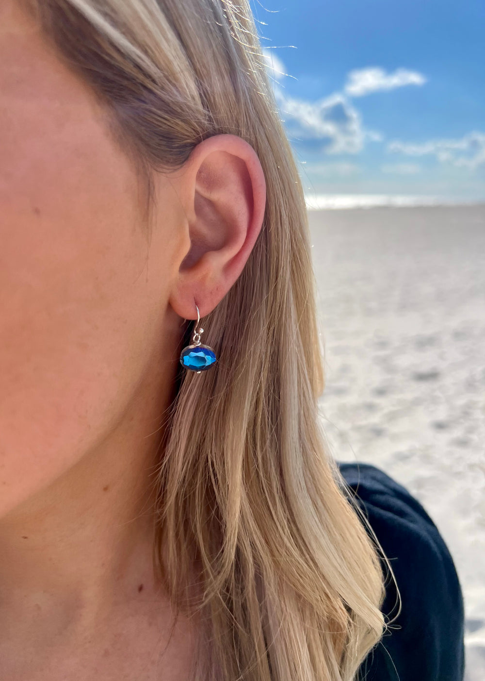 Tara silver dangle earrings with blue reflective detail in ear