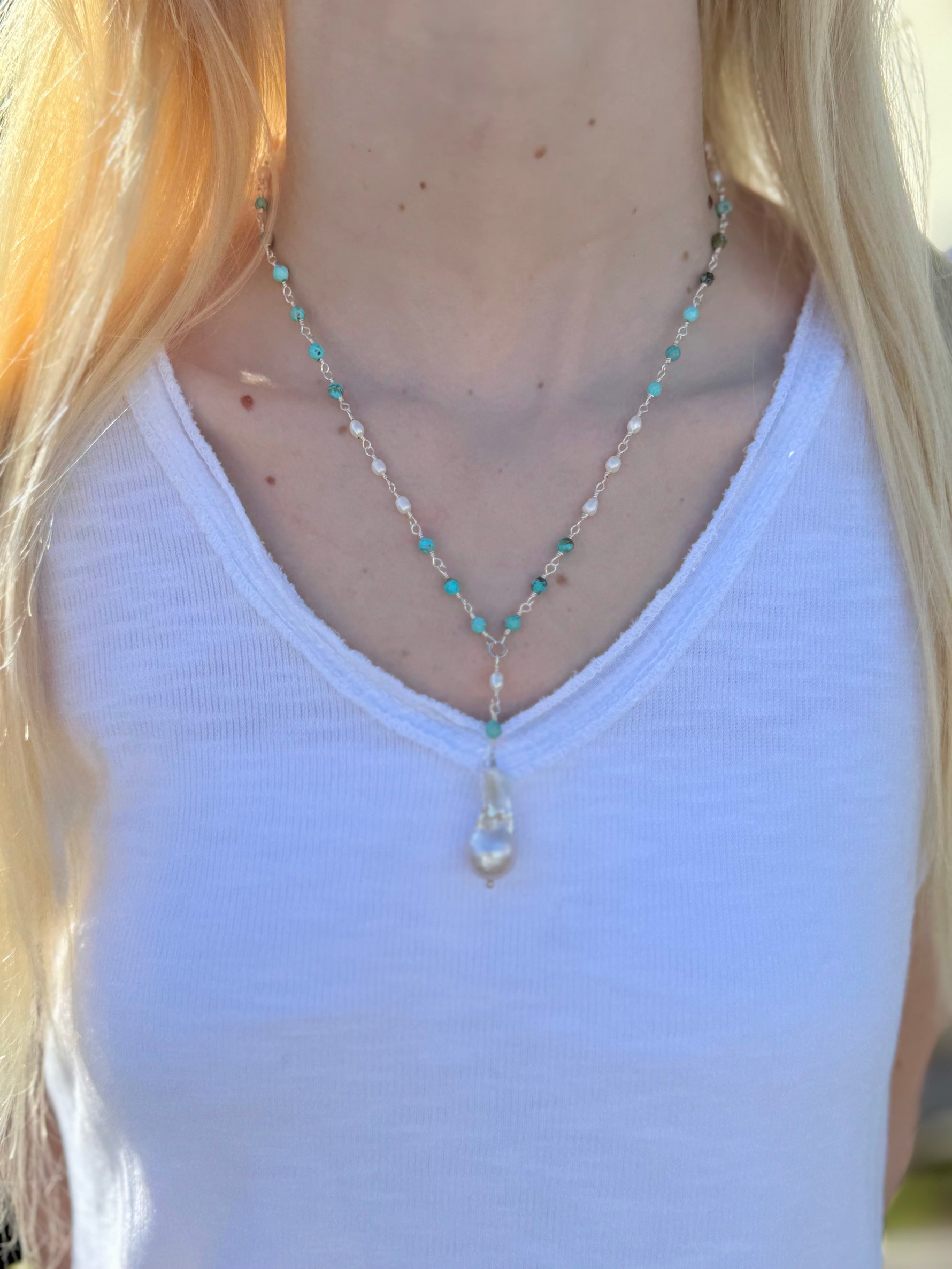 Close-up of Sofia Biwa Pearl and Amazonite Necklace on model, Y-shaped chain with Biwa pearl drop, worn with a white V-neck tank top.