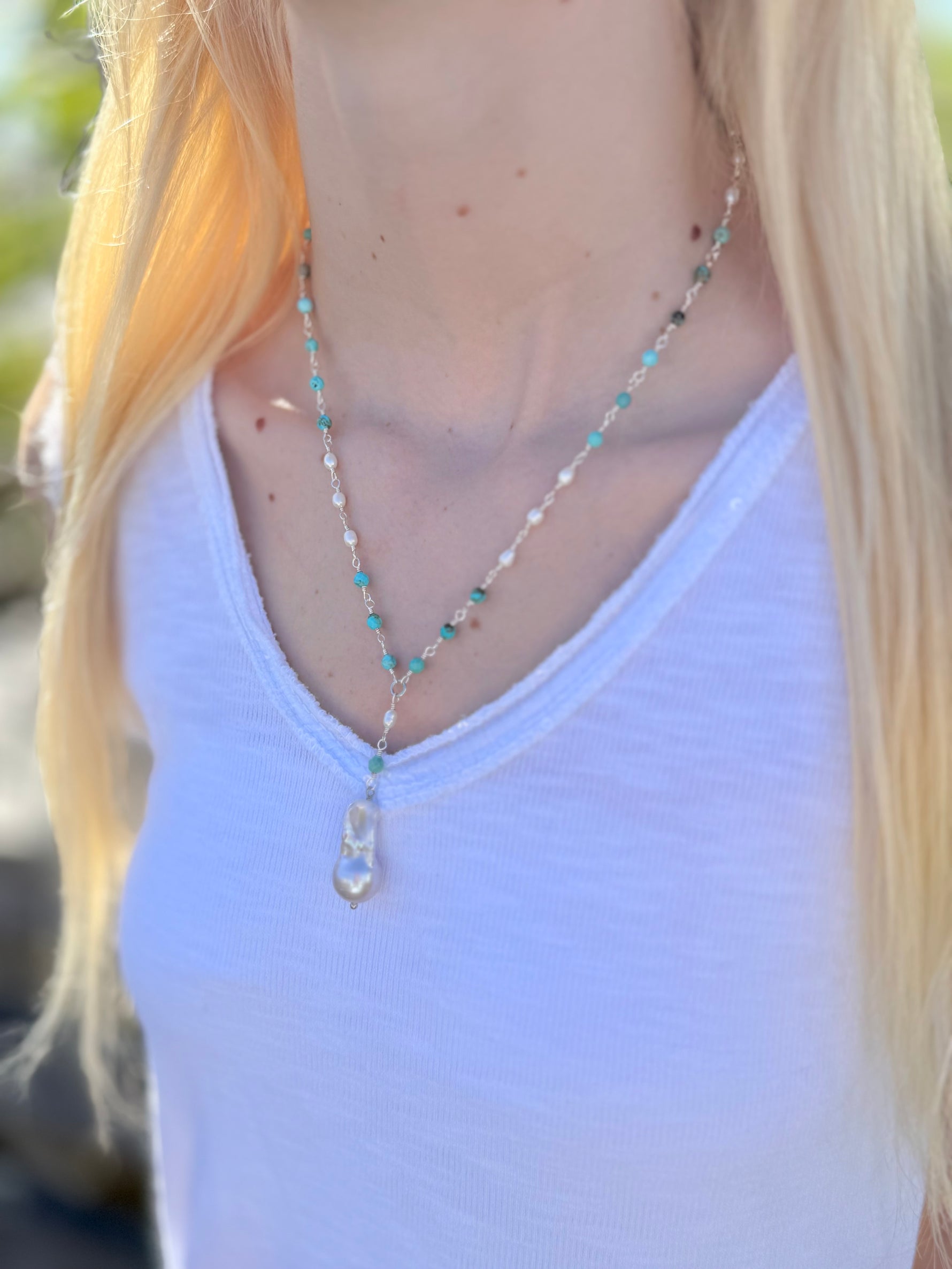Side view of Sofia Biwa Pearl and Amazonite Necklace, amazonite beads and Biwa pearl drop layered over a white V-neck tank in natural light.