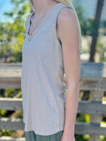 Side view of beige sequin tank showing raw-edge trim and lightweight knit texture.