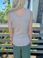 Back view close-up of beige tank showing sequin trim and textured straps.