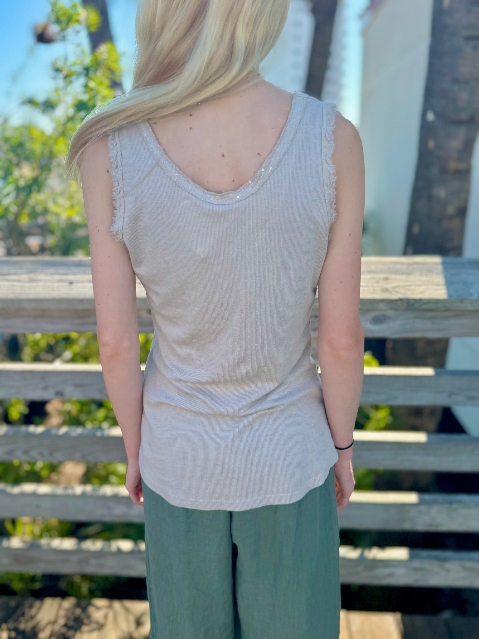 Back view close-up of beige tank showing sequin trim and textured straps.