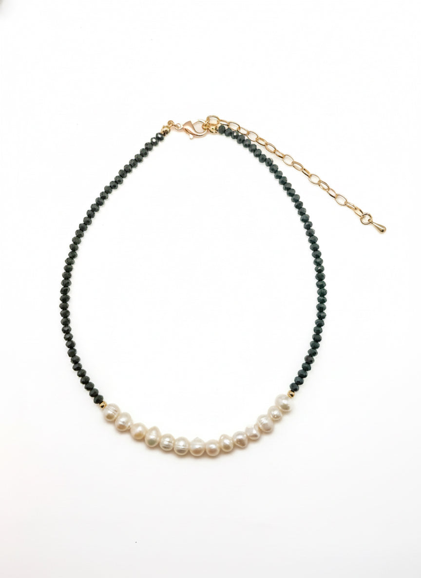 A necklace featuring deep olive faceted beads and a row of freshwater pearls with a gold clasp and extender, displayed on a white background.