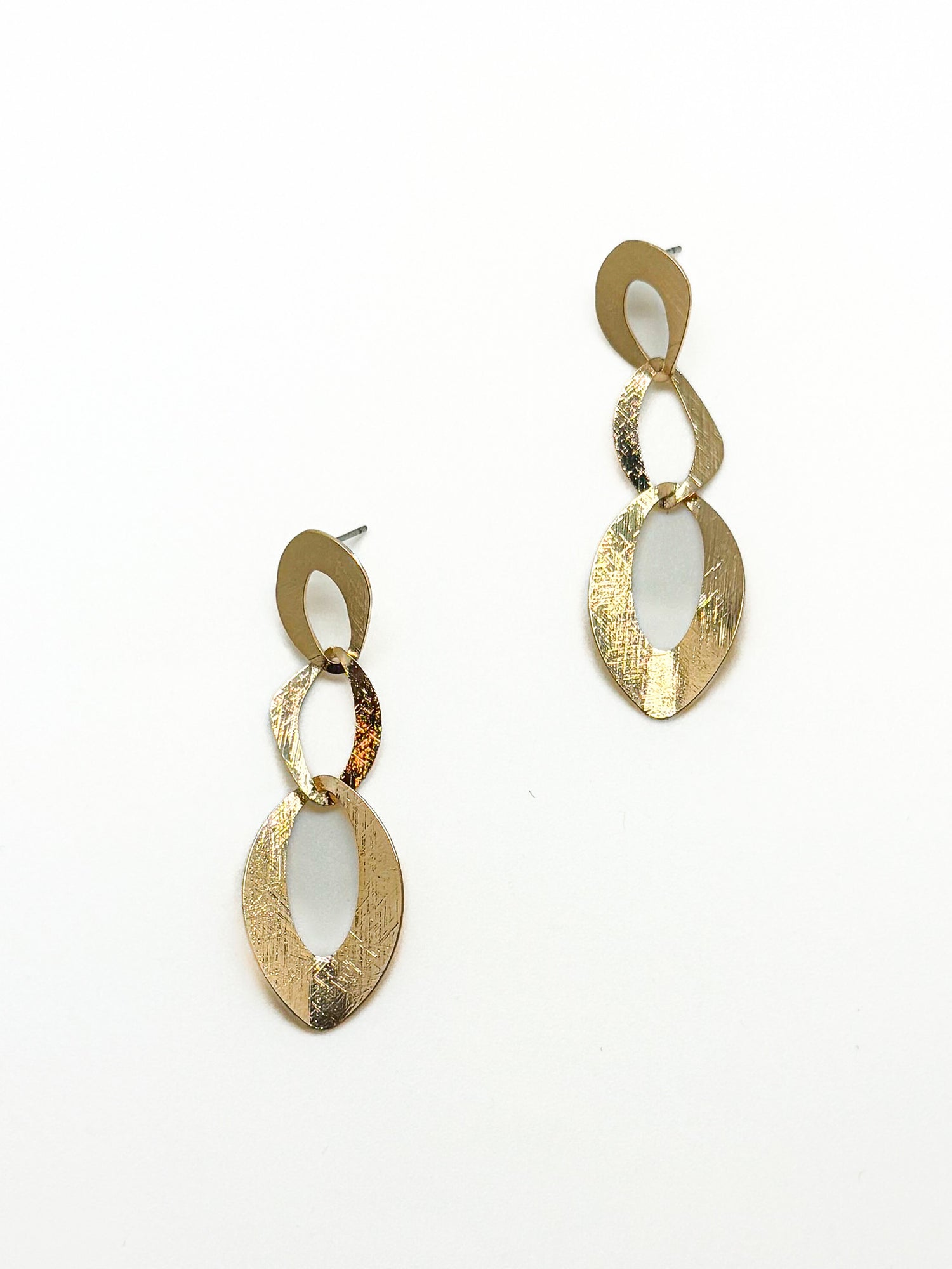 Gold dangly earrings with linked, open shapes on a white background