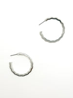 Silver hoop earrings on a white background