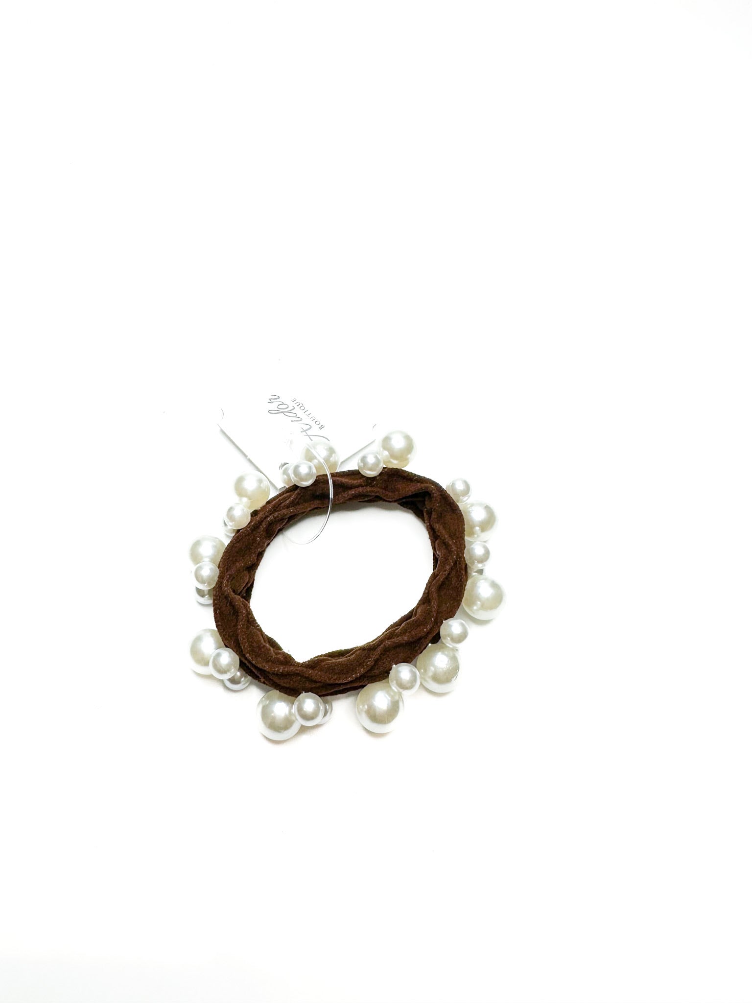 Hair tie with brown yarn and pearls on a white background