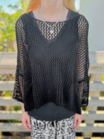 Person wearing a black mesh sweater 