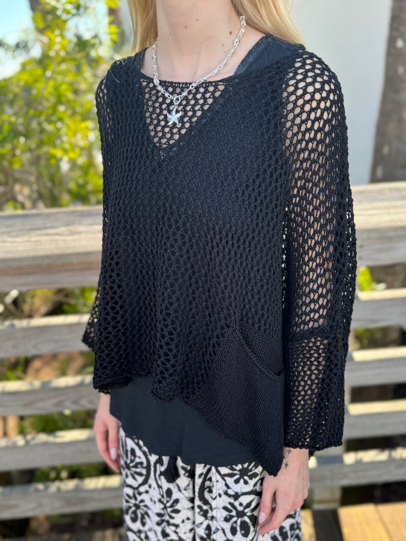 Side view of a person wearing a black sweater top 