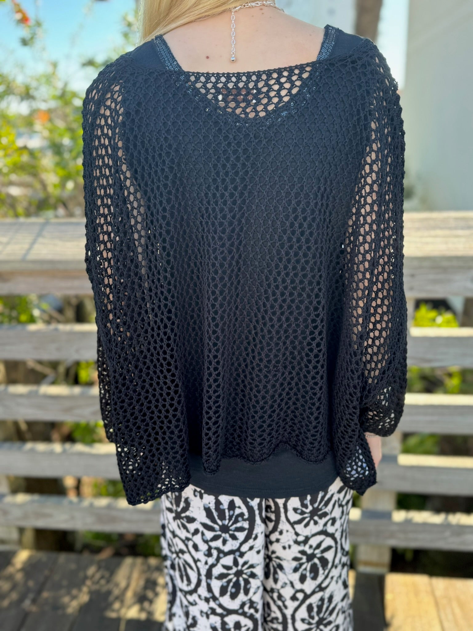 Back view of a person wearing a black sweater 