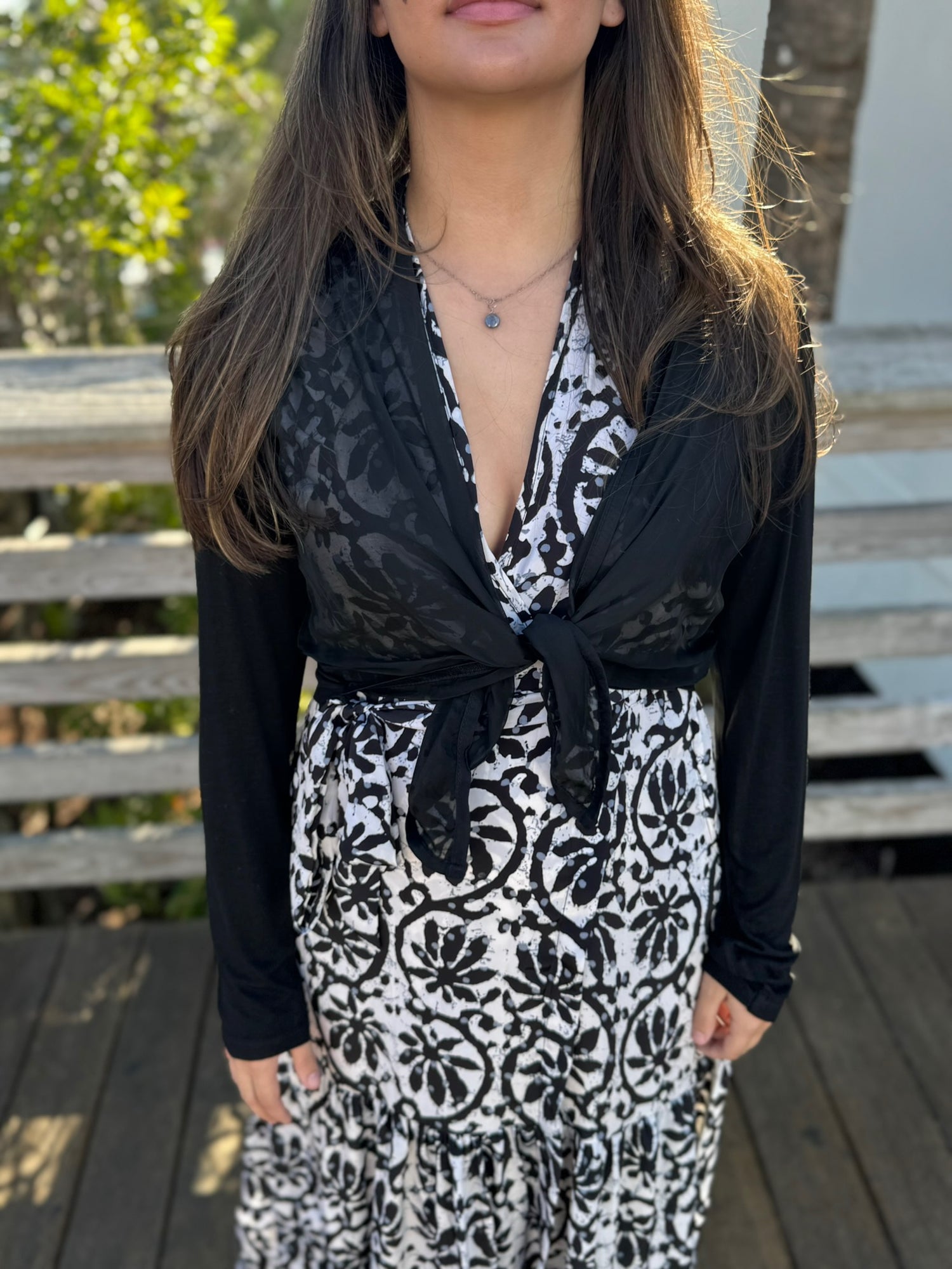 Woman wearing a black and white patterned dress with a blurred background