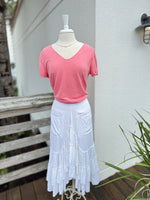White skirt paired with a coral V neck tee 