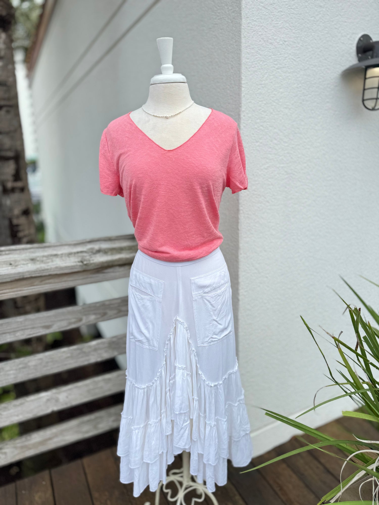 White skirt paired with a coral V neck tee 