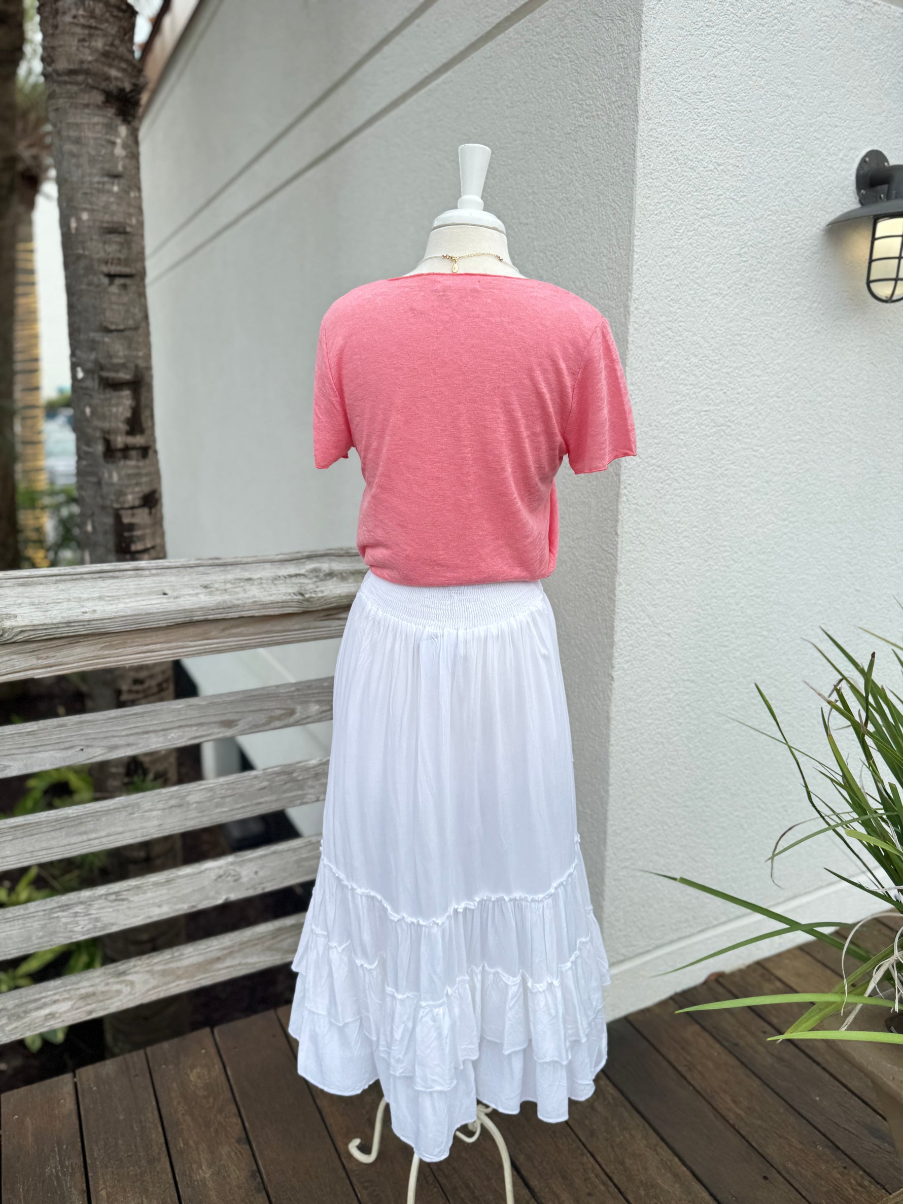 White skirt paired with a coral V neck tee 