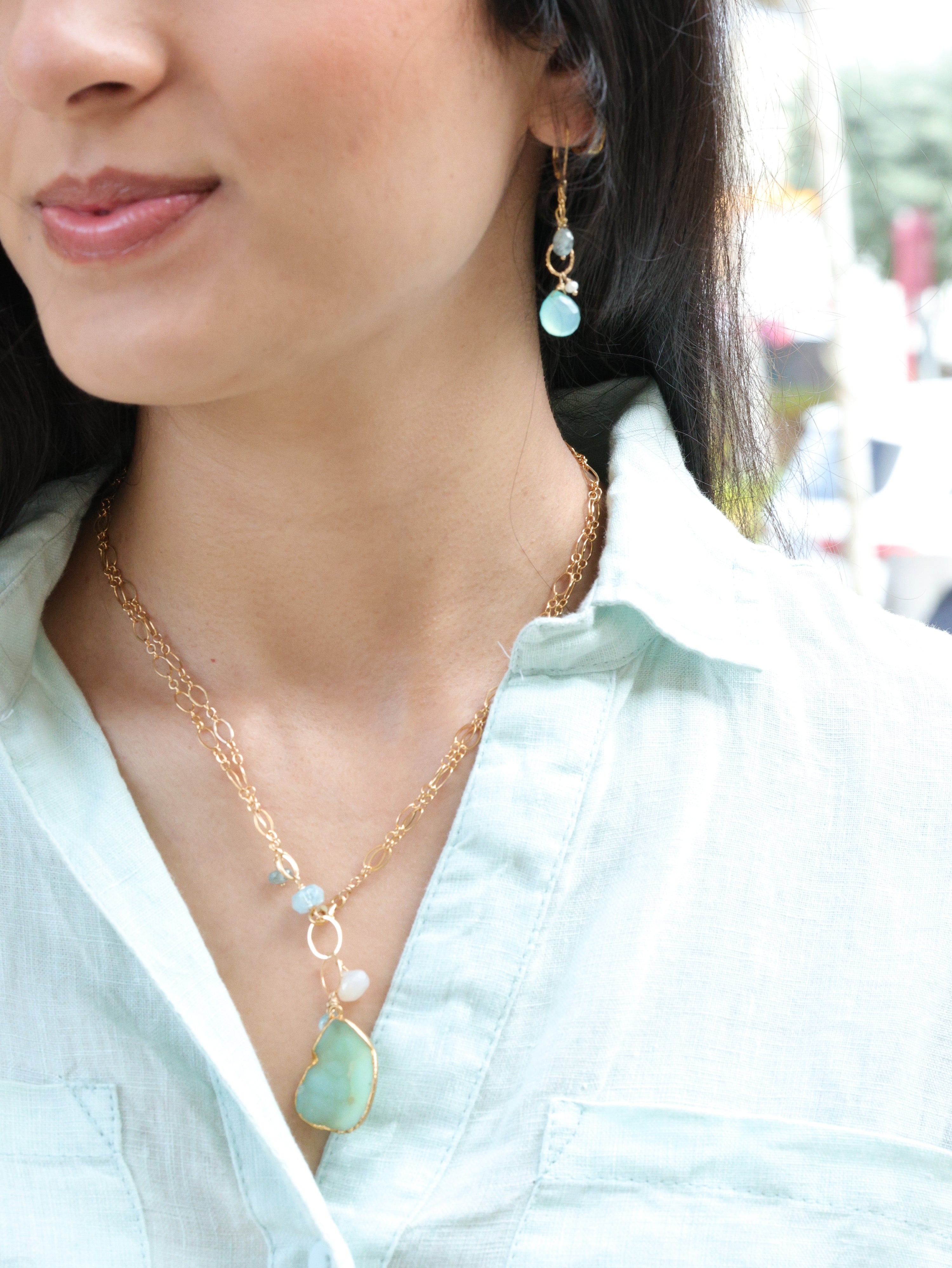 swinging gemstone earrings on model w/ necklace