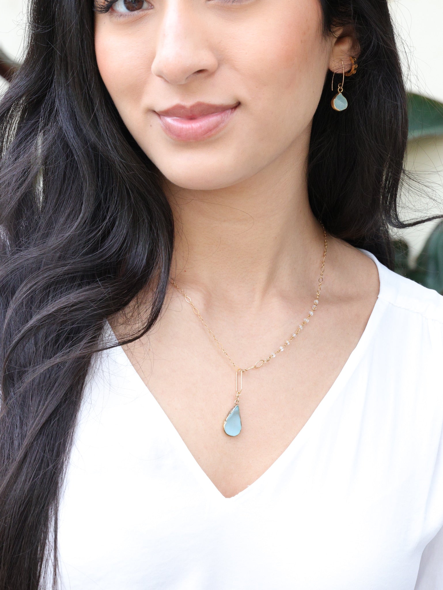 teardrop druzy necklace paired with earrings form the nh Aqua gold collection on model 