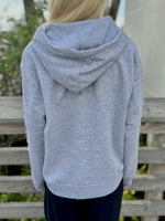 Person wearing a gray hoodie with a blurred background