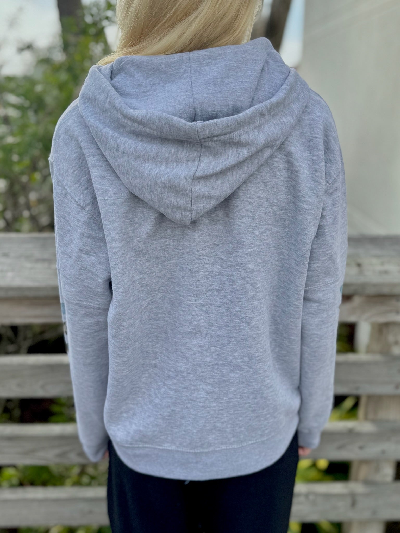 Person wearing a gray hoodie with a blurred background