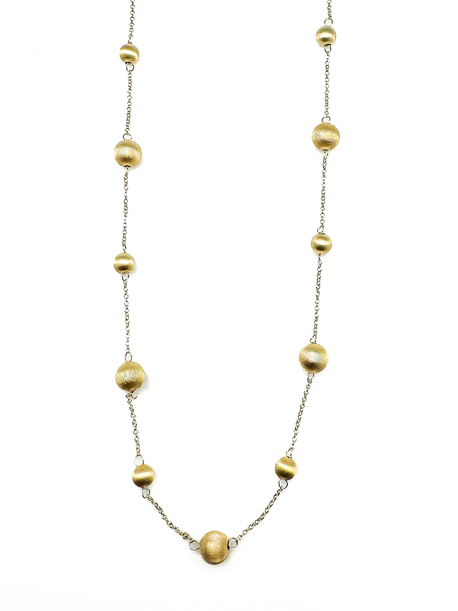 Gold plated sterling silver bead station necklace photographed on a white background