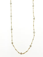 Gold necklace with small pearls on a white background