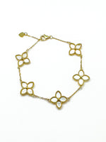 Gold bracelet with floral designs on a white background