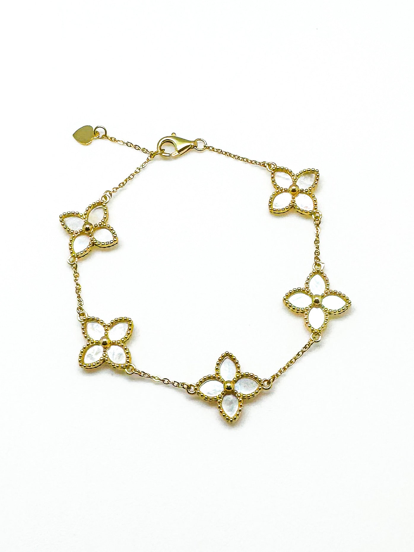 Gold bracelet with floral designs on a white background