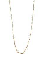 Gold chain necklace with small silver beads on a white background