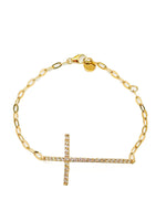 Gold bracelet with a cross charm on a white background