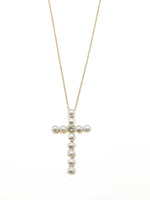Pearl cross necklace on a gold chain against a white background