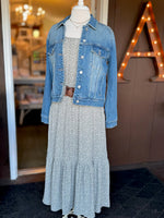Olive green and white floral maxi dress styled with a blue denim jacket and brown waist belt for transitional weather at Ardor Boutique.